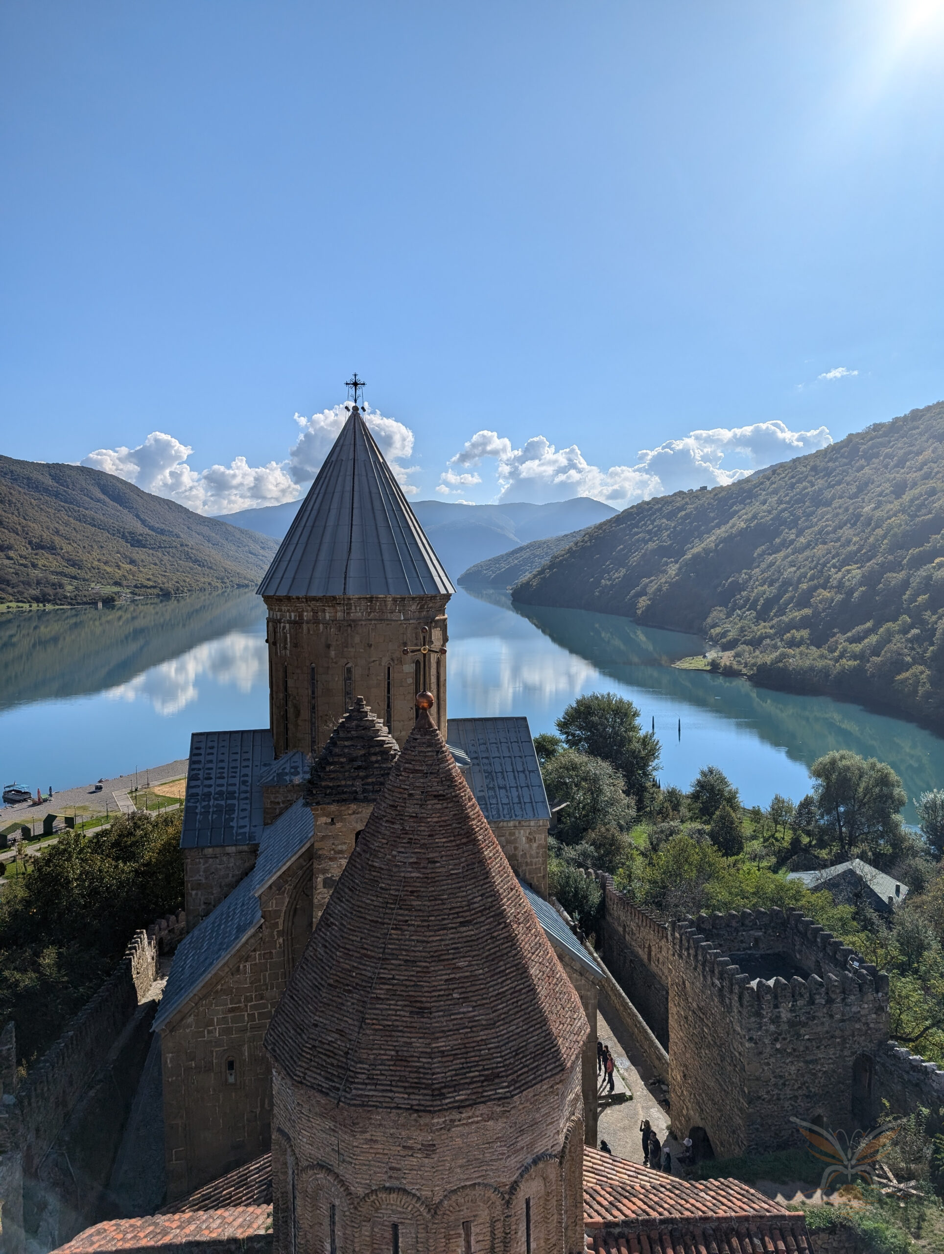 Stone church tower of Ananuri Fortress overlooking the Zhinvali Reservoir and surrounding hills in Georgia.