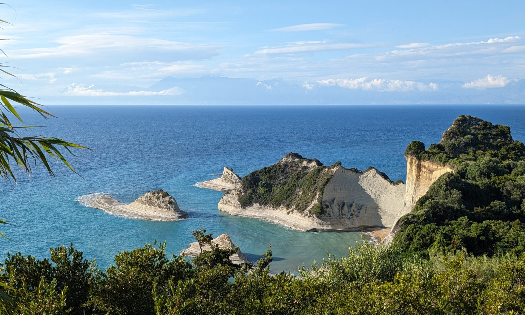 Panoramic view of Cape Drastis with pale cliffs, green vegetation and open sea in Corfu.