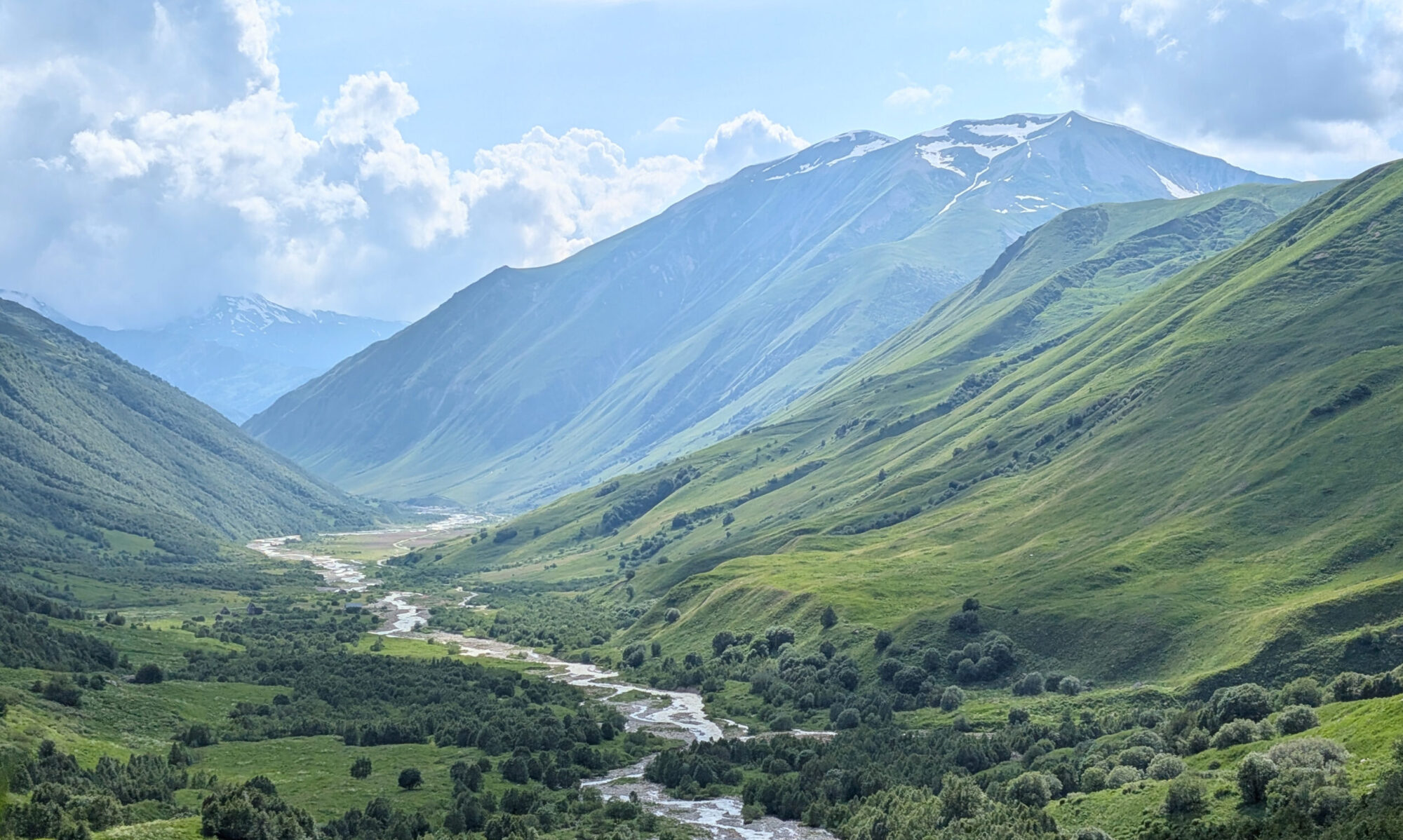 Enguri River winding through a broad green mountain valley near Shkhara in Svaneti.