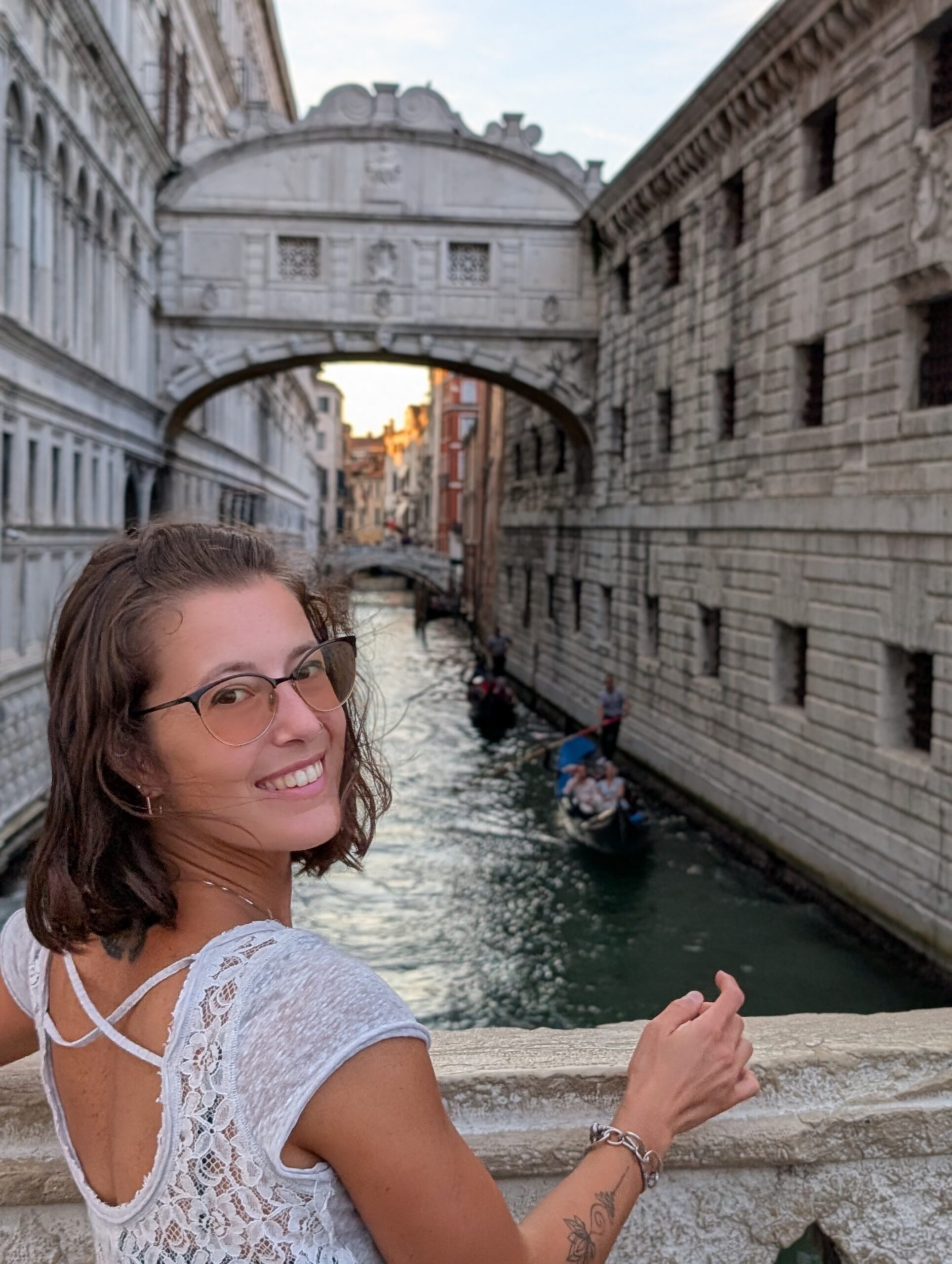 Mariachiara smiling beside a Venetian canal with the Bridge of Sighs in the background.