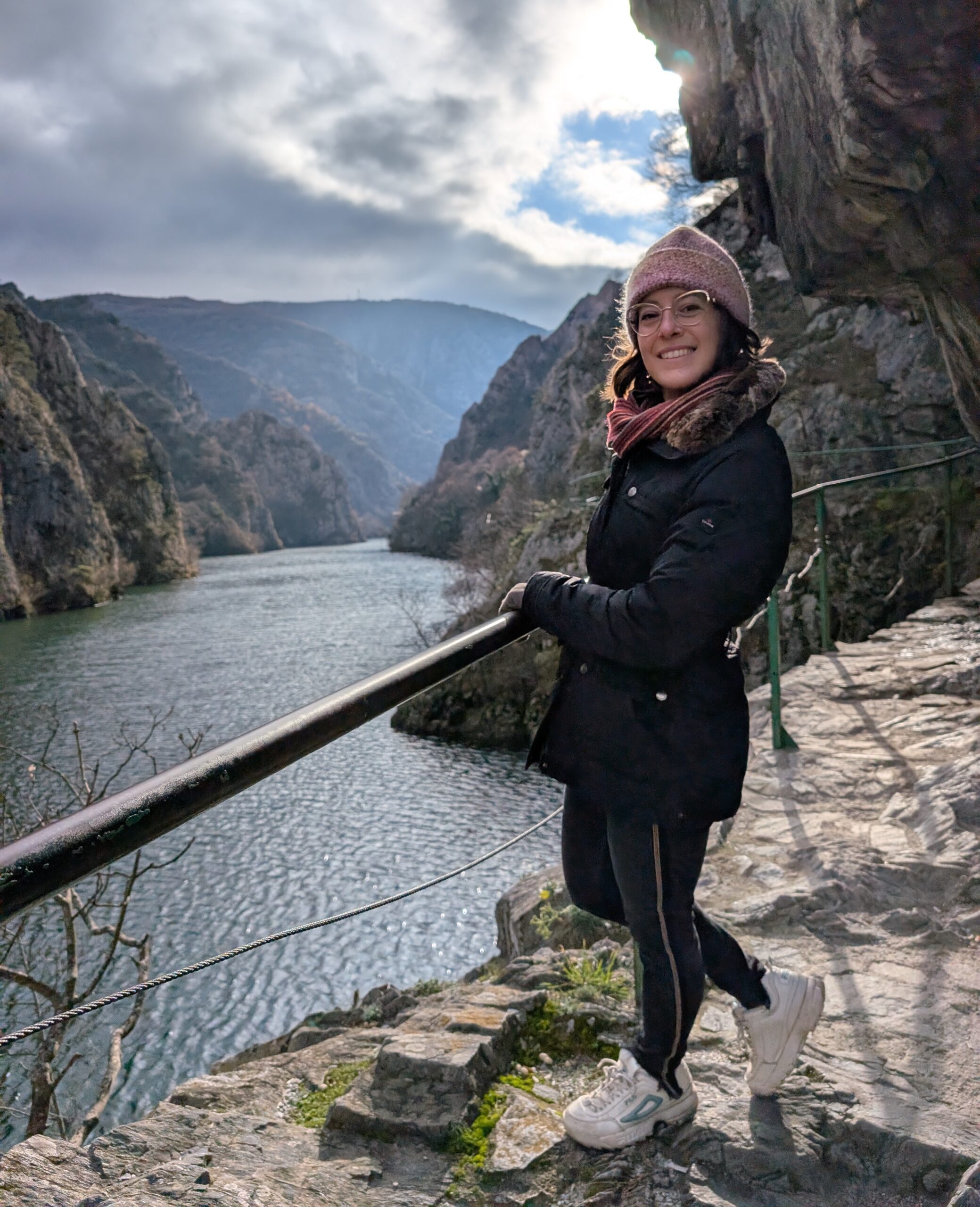Mariachiara smiling on a cliffside path overlooking Matka Canyon in North Macedonia.