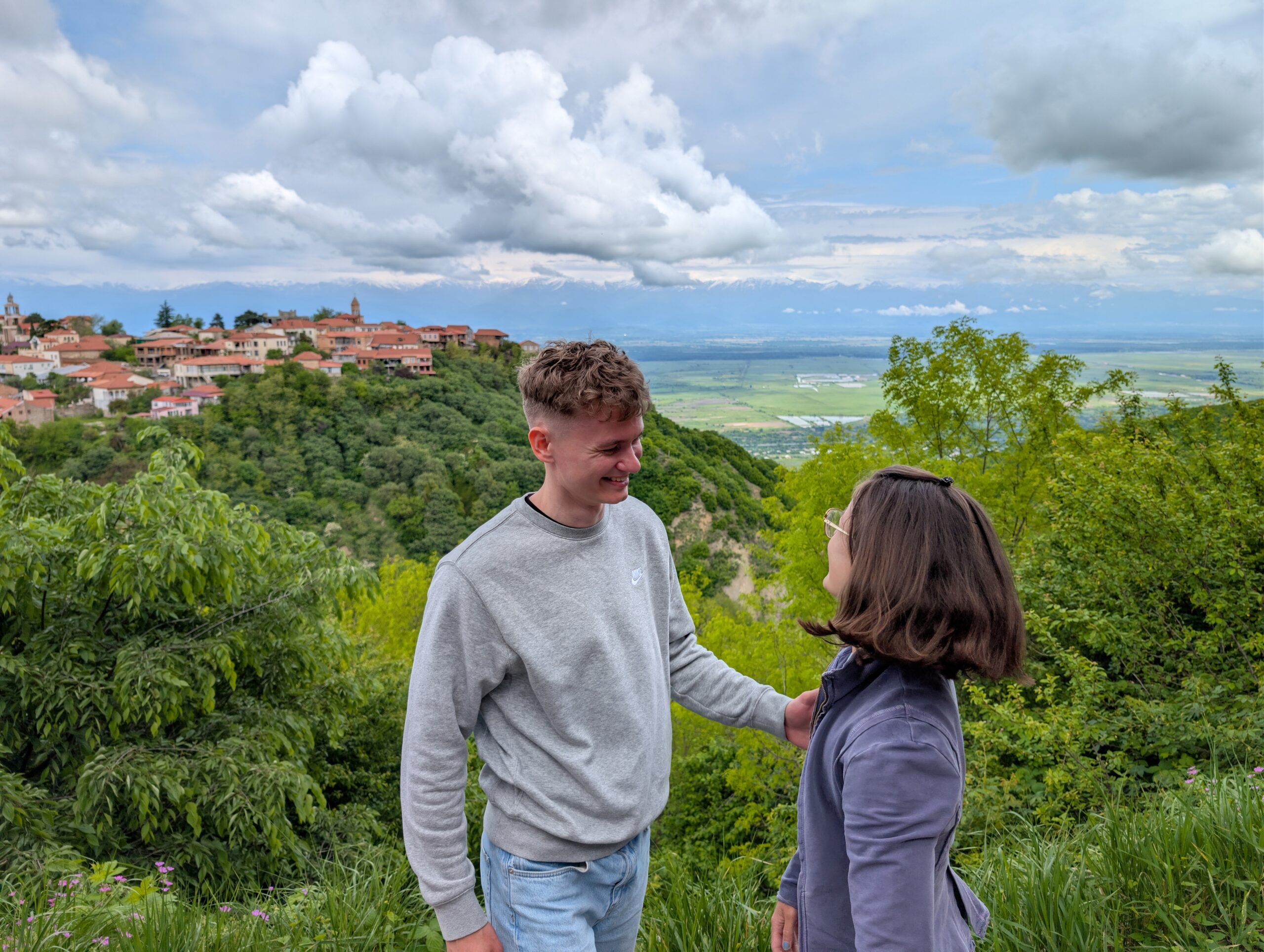 Mariachiara sharing a quiet moment with a companion at a green hillside viewpoint in Georgia.
