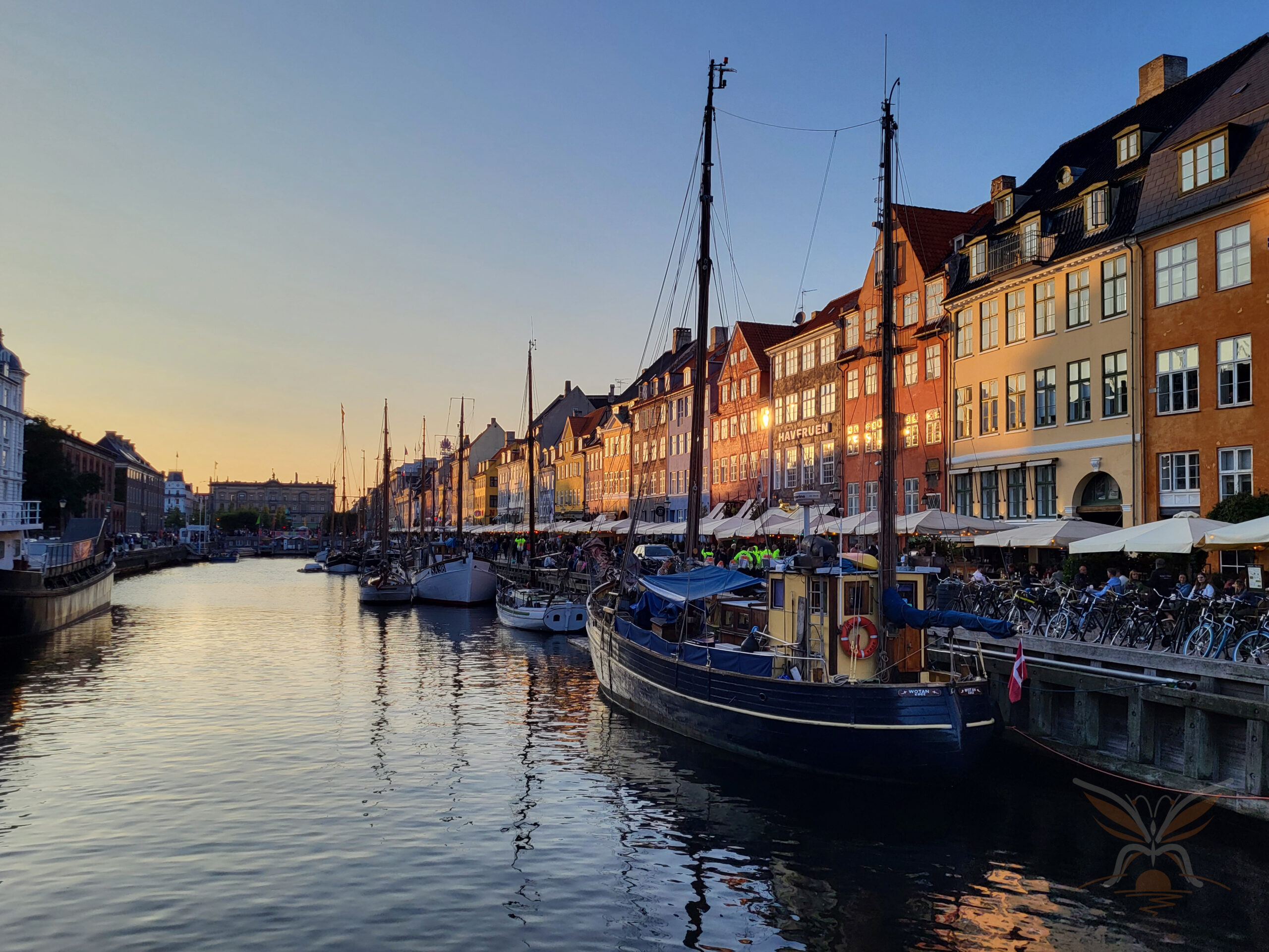 Nyhavn's colourful waterfront and moored boats in warm evening light in Copenhagen.