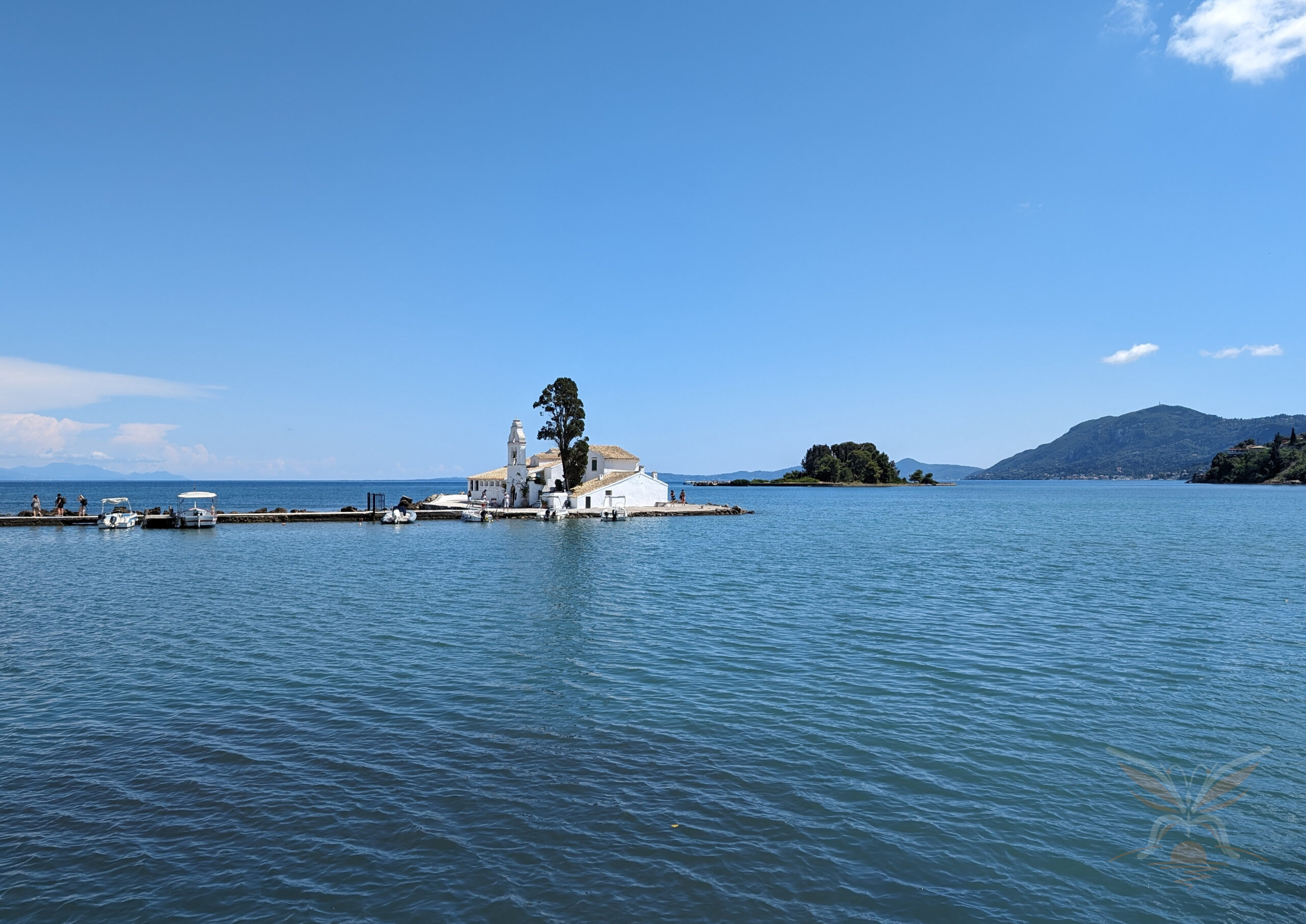 Vlacherna Monastery on a small islet surrounded by calm blue water in Corfu, Greece.