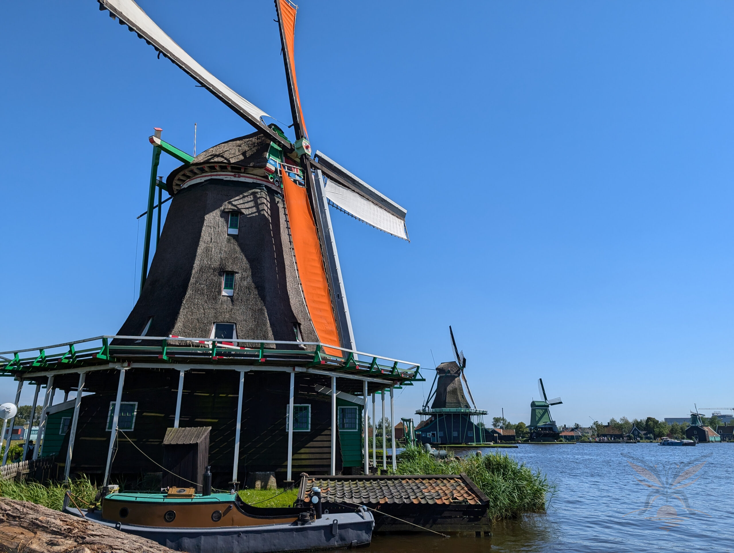 Traditional windmills beside the water at Zaanse Schans in the Netherlands.
